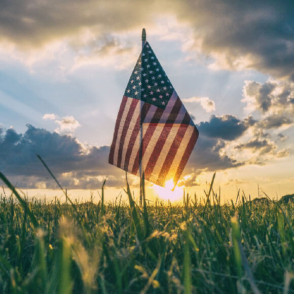 Small American flag stuck into some grass